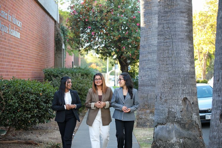 Three women walking on campus